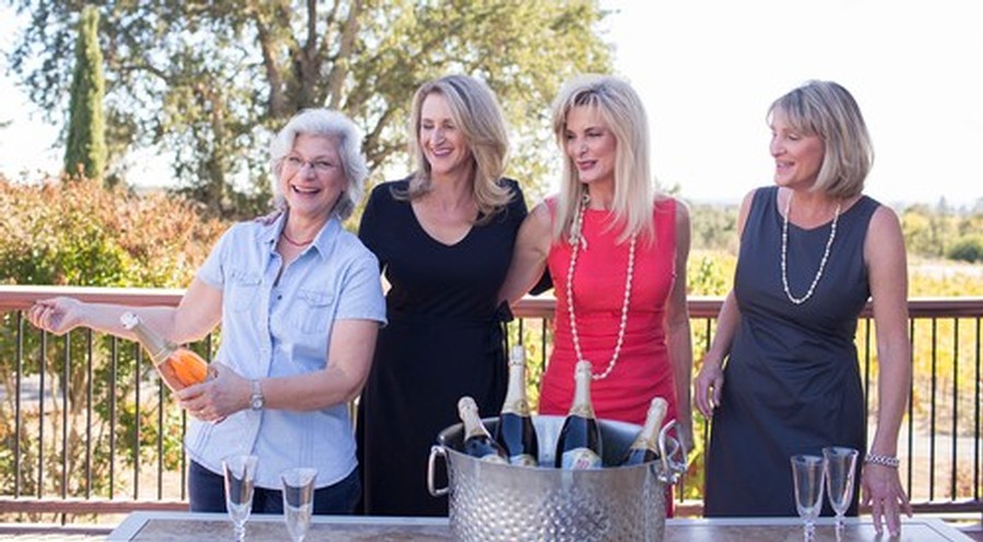 The Breathless sisters and wine maker Penny standing together and smiling